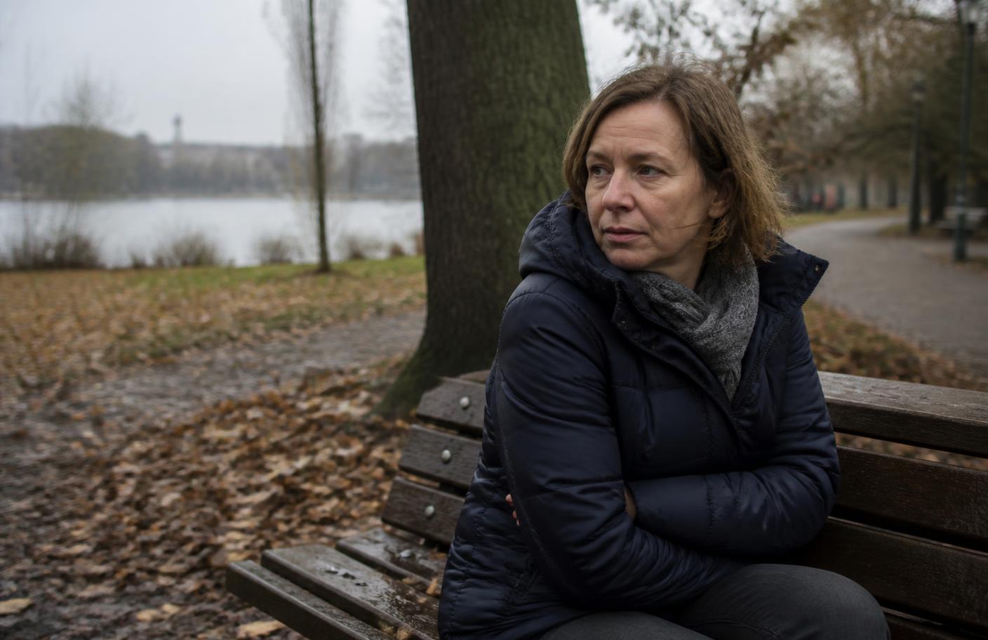 Frau auf einer kalten Parkbank im Herbst